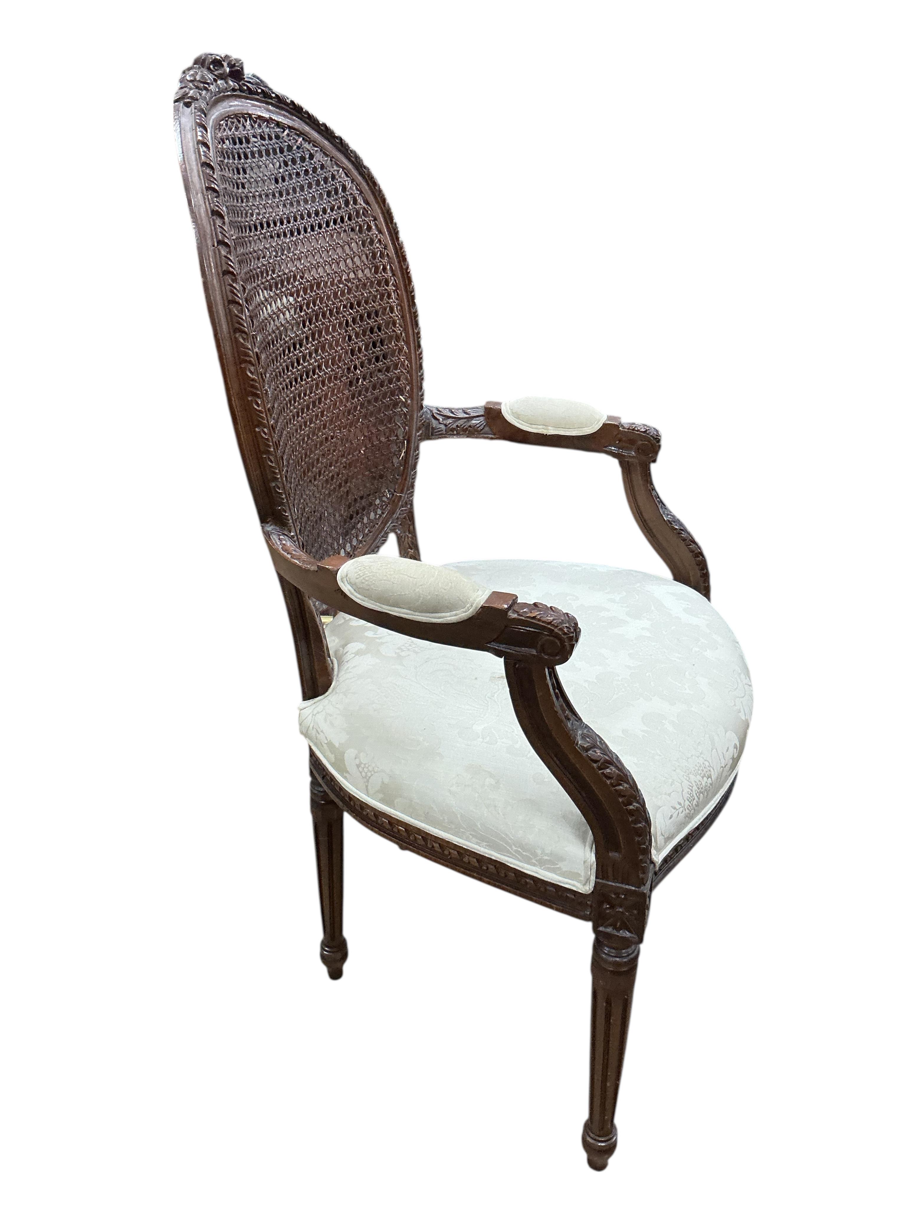 An early 20th century French carved caned mahogany elbow chair in Louis XVI style, width 61cm, depth 53cm, height 112cm